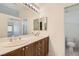 Bathroom featuring a double vanity with a large mirror and ample lighting, next to the toilet area at 3636 Remington Grove Ave, North Las Vegas, NV 89081