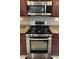 Stainless steel range top and oven with microwave above, granite countertops, and wood cabinets at 3720 Rocklin Peak Ave, North Las Vegas, NV 89081