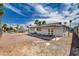 A large backyard showcases rock landscaping, a covered patio, and mature palm trees at 4484 Bennett Dr, Las Vegas, NV 89121