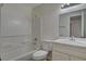 An all white bathroom features an updated vanity, mirror, lighting, and shower-tub combo at 4484 Bennett Dr, Las Vegas, NV 89121