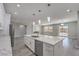 Open-concept kitchen with white cabinets, stainless appliances, quartz countertops, and views of living area at 4781 Stoneham, Pahrump, NV 89061