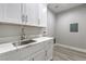Functional laundry room with white cabinets, sink, and modern hardware at 4781 Stoneham, Pahrump, NV 89061
