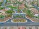 Neighborhood entry featuring manicured landscaping, palm trees, and a decorative entry gate at 4878 Califa Dr, Las Vegas, NV 89122
