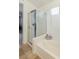 This bathroom features a combined bathtub and shower with tiled walls and glass door, and white walls at 4878 Califa Dr, Las Vegas, NV 89122