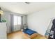A minimalist bedroom with hardwood floors, gray curtains, a window with natural light, and a simple mattress on the floor at 4878 Califa Dr, Las Vegas, NV 89122