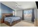 Spacious bedroom featuring a large window, ceiling fan, and a comfortable bed with drawer storage at 4878 Califa Dr, Las Vegas, NV 89122
