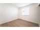 Well-lit bedroom with light wood floors and a window with blinds, showcasing a clean and simple design at 5751 Mabel Rd, Las Vegas, NV 89110