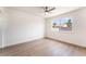 Bright bedroom featuring a ceiling fan, light wood floors, and a large window showcasing the outside view at 5751 Mabel Rd, Las Vegas, NV 89110