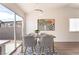 Cozy dining space with modern light fixture and view of the backyard through sliding glass door at 5751 Mabel Rd, Las Vegas, NV 89110