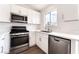 Well-lit kitchen featuring stainless steel appliances, white cabinets, a view from the window, and clean countertops at 5751 Mabel Rd, Las Vegas, NV 89110