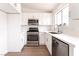 Modern kitchen with stainless steel appliances, white cabinets, a window over the sink, and light wood floors at 5751 Mabel Rd, Las Vegas, NV 89110