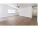 Minimalist living room with light wood floors, white walls, and a ceiling fan, offering a blank canvas for personalization at 5751 Mabel Rd, Las Vegas, NV 89110