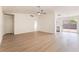 Bright open-concept living room with light wood floors, a ceiling fan, and seamless access to the kitchen at 5751 Mabel Rd, Las Vegas, NV 89110