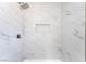 Modern shower with marble-patterned tile, featuring a niche for storage and a rain shower head at 5751 Mabel Rd, Las Vegas, NV 89110