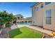 This home's exterior overlooks a refreshing swimming pool and covered patio, complemented by an artificial turf area at 5823 Rose Sage St, North Las Vegas, NV 89031