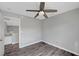 A simple bedroom featuring hardwood floors, a ceiling fan, and an attached hallway at 5823 Rose Sage St, North Las Vegas, NV 89031