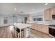 Spacious kitchen with stainless steel appliances, pink cabinets, and an open layout to the living room at 5823 Rose Sage St, North Las Vegas, NV 89031