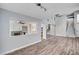 Open-concept living room with wood-look flooring, fireplace, and views into the kitchen at 5823 Rose Sage St, North Las Vegas, NV 89031