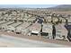 Expansive aerial shot capturing a neighborhood with modern homes, desert landscape and mountain views in the distance at 6322 Angora Peak Ln, Las Vegas, NV 89115