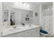 Bright bathroom features a double sink vanity, large mirror, and shower with a decorative curtain at 6322 Angora Peak Ln, Las Vegas, NV 89115