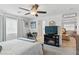 Bedroom featuring a ceiling fan, TV, desk, and ensuite bathroom entrance at 6322 Angora Peak Ln, Las Vegas, NV 89115