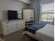 Bedroom featuring a tv, dresser with a mirror and a sun-filled window at 6650 W Warm Springs Rd # 2159, Las Vegas, NV 89118