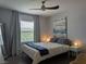 Cozy bedroom with a comfortable bed, large window, and modern ceiling fan at 6650 W Warm Springs Rd # 2159, Las Vegas, NV 89118
