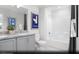 Bathroom featuring double sinks, granite countertop, framed mirrors, and a shower-tub combo at 6740 Nimbus Ave # Lot 10, Las Vegas, NV 89130