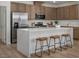Stylish kitchen boasts stainless steel appliances, white quartz countertops, island with seating, and wood cabinets at 739 Wild Highlands Ln, Henderson, NV 89015