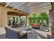 Charming covered patio with comfortable seating, a dining area, and a view of the beautifully landscaped yard at 748 Puerto Real Ct, Las Vegas, NV 89138