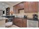 Home bar features dark wood cabinets, granite counters, sink, and stainless steel beverage refrigerator at 748 Puerto Real Ct, Las Vegas, NV 89138