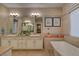 Luxurious bathroom featuring double vanity, soaking tub, and neutral tile work at 748 Puerto Real Ct, Las Vegas, NV 89138