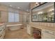 Well-appointed bathroom with a soaking tub, glass enclosed shower and vanity with seating at 748 Puerto Real Ct, Las Vegas, NV 89138