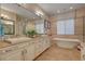 Elegant bathroom featuring double vanity, soaking tub, separate glass shower, and neutral color palette at 748 Puerto Real Ct, Las Vegas, NV 89138