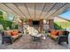 Inviting outdoor living space with stone fireplace, TV, comfortable seating, and elegant brick patio at 748 Puerto Real Ct, Las Vegas, NV 89138
