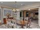 Elegant dining room featuring chandelier, designer window coverings, and access to outdoor area at 748 Puerto Real Ct, Las Vegas, NV 89138