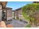 Inviting entryway with stone water feature, tiled floor, wrought iron gate, and lush landscaping at 748 Puerto Real Ct, Las Vegas, NV 89138