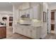 Charming kitchen featuring white cabinets, tiled backsplash, stainless steel appliances, and wood flooring at 748 Puerto Real Ct, Las Vegas, NV 89138