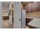 Convenient laundry room with ample cabinet space, utility sink, and full-size refrigerator at 748 Puerto Real Ct, Las Vegas, NV 89138