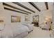 Bright bedroom with dark wood beamed ceiling, detailed wall trim, and an upholstered chaise at 748 Puerto Real Ct, Las Vegas, NV 89138