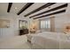 Spacious bedroom with a dark wood beamed ceiling, accent wall, and lots of natural light at 748 Puerto Real Ct, Las Vegas, NV 89138