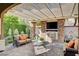 Covered outdoor living area with fireplace, tv, seating area, and pavers at 748 Puerto Real Ct, Las Vegas, NV 89138