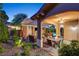 Relaxing outdoor living space has a stone fireplace, ceiling fan, dining area, and seating at 748 Puerto Real Ct, Las Vegas, NV 89138