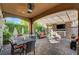 Covered outdoor living area with fireplace, tv, seating area, and a dining area at 748 Puerto Real Ct, Las Vegas, NV 89138