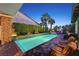 Relaxing backyard with long pool, palm trees, and lounge chairs, perfect for a summer evening at 748 Puerto Real Ct, Las Vegas, NV 89138