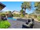 Backyard with a tranquil pool and spa surrounded by mature landscaping and comfortable seating areas at 748 Puerto Real Ct, Las Vegas, NV 89138