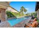 Backyard with pool, spa, palm trees, privacy landscaping, and patio seating area at 748 Puerto Real Ct, Las Vegas, NV 89138