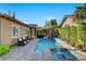 Beautiful backyard with a long pool and spa, surrounded by a stone patio and lush landscaping at 748 Puerto Real Ct, Las Vegas, NV 89138