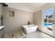Modern bathroom boasts a freestanding tub, separate walk-in shower and stylish fixtures with a view of the backyard pool at 8000 Vista Twilight Dr, Las Vegas, NV 89123