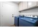 Laundry room featuring a door, cabinets, washing machine, and dryer at 8000 Vista Twilight Dr, Las Vegas, NV 89123
